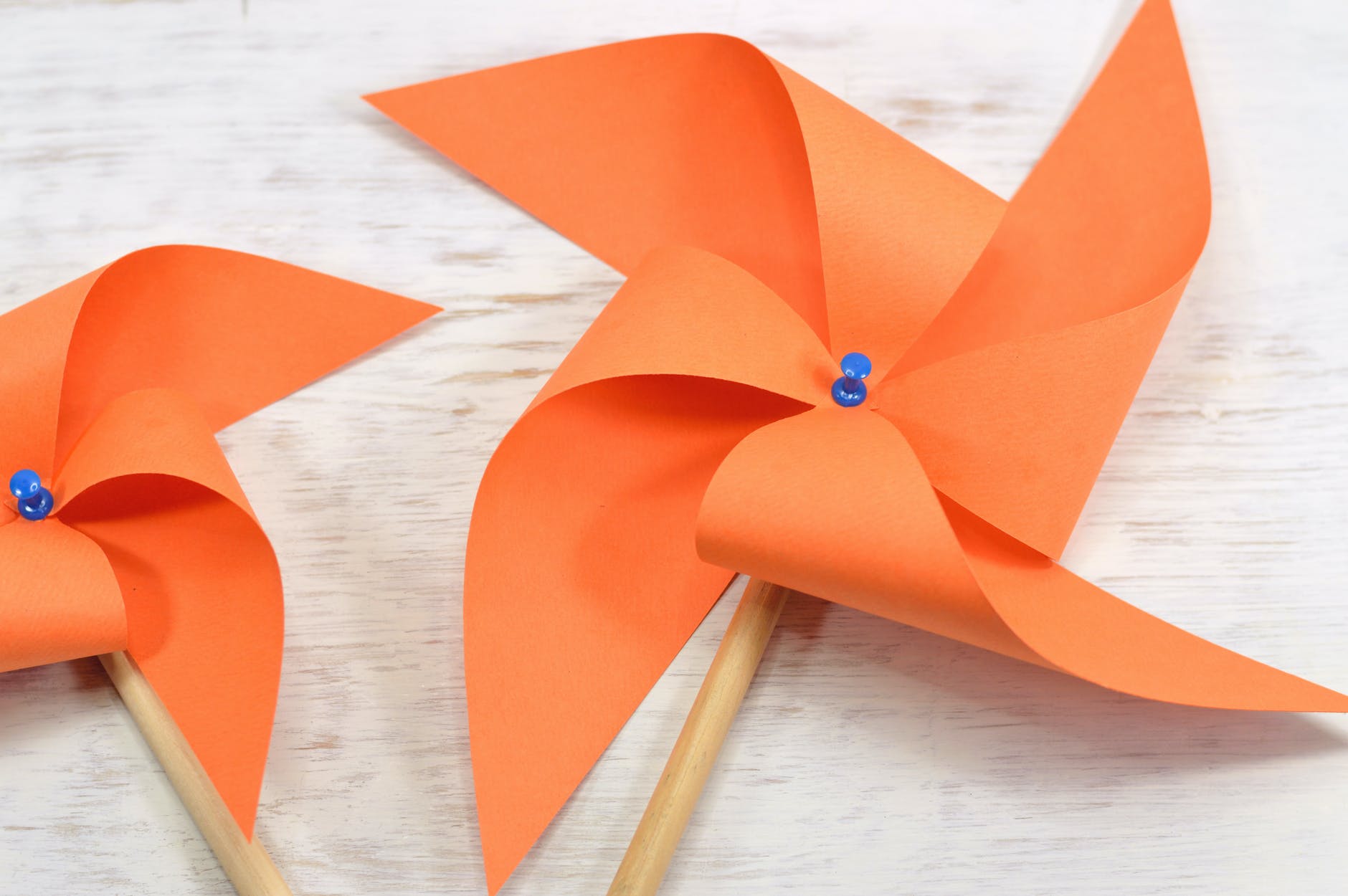 two orange paper windmills