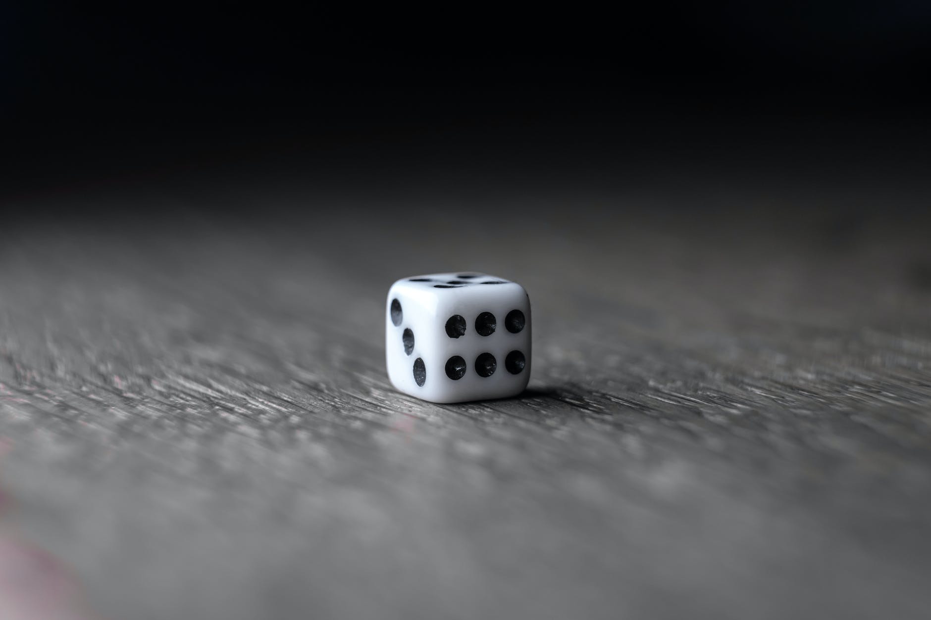 small white dice placed on wooden table